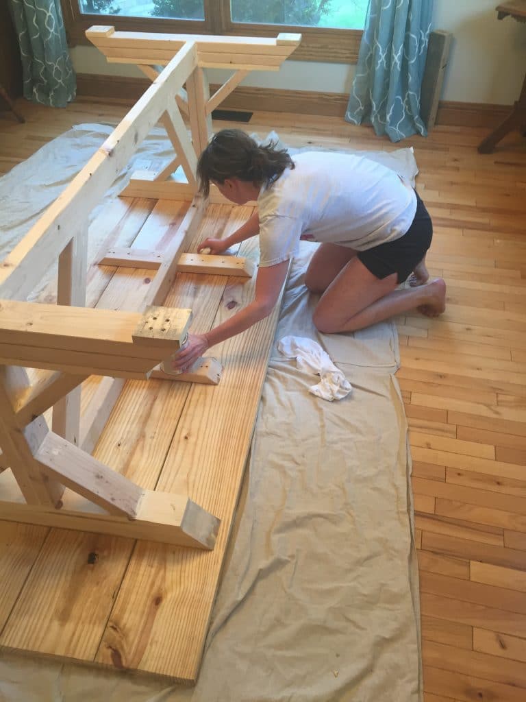 Wiping the first layer of stain on the dining table.