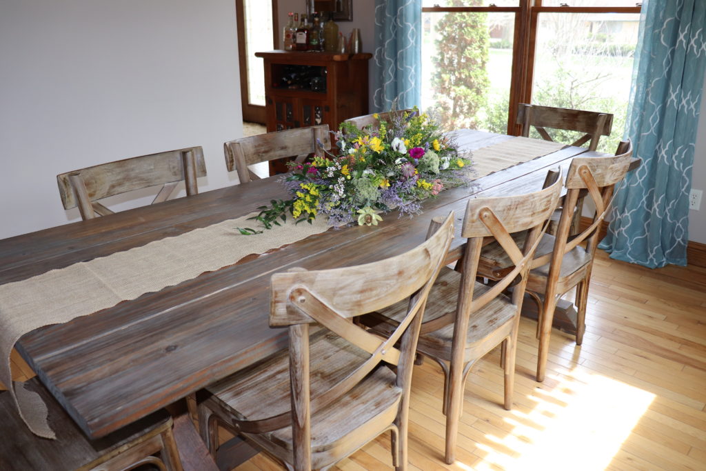 DIY Farmhouse Dining Table with a flower arrangement in the middle