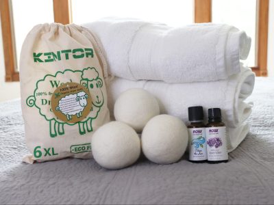 wool dryer balls and essential oil in front of folded towels