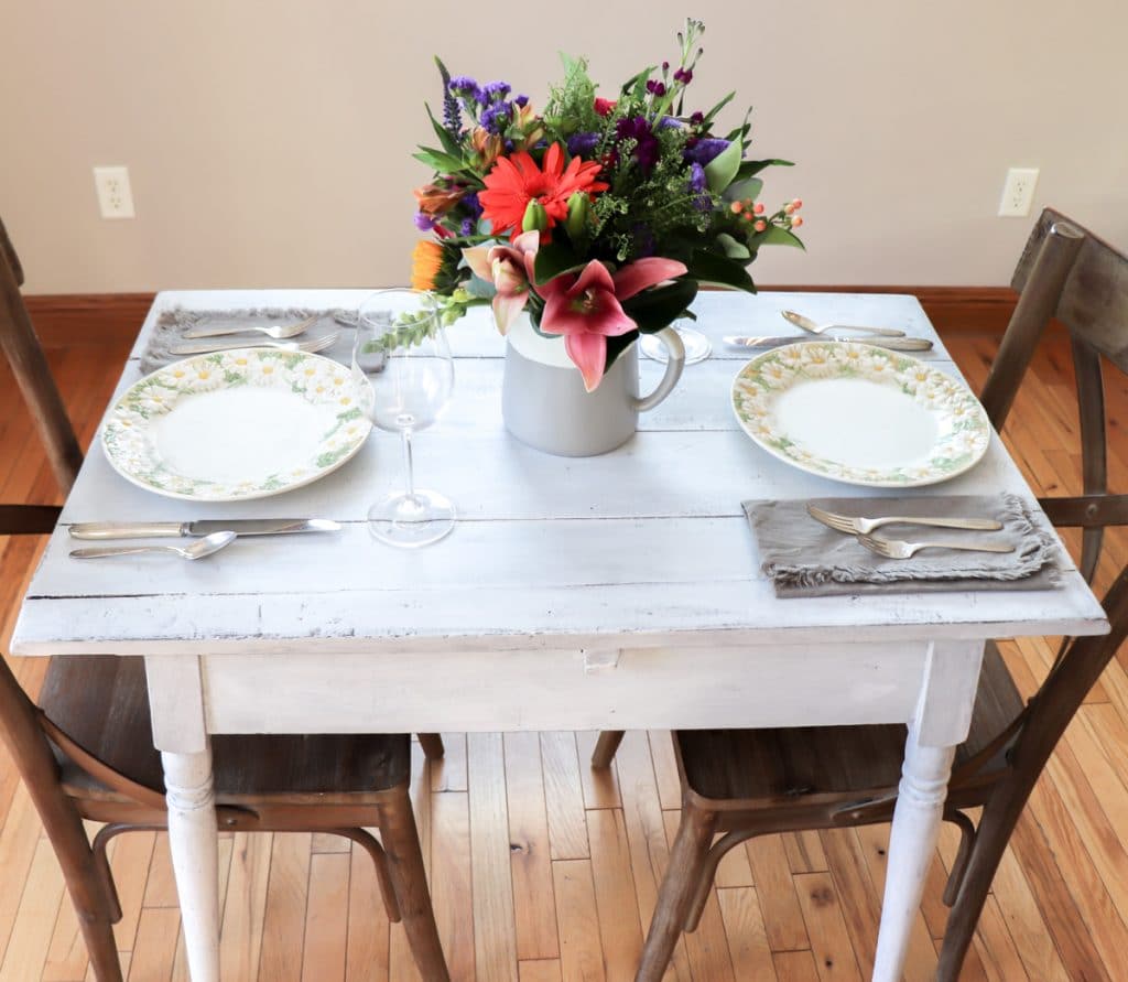 painting a table white showing table with place setting for two