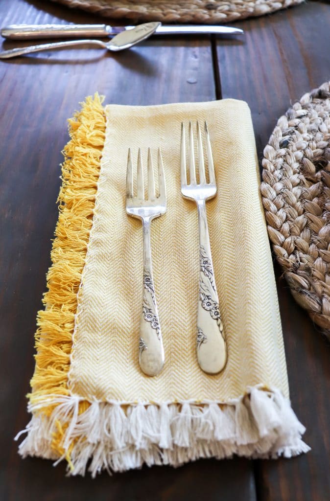 yellow napkin with silver flatware