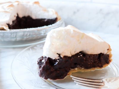 Slice of Old Fashioned Chocolate Meringue Pie sitting on a clear plate.