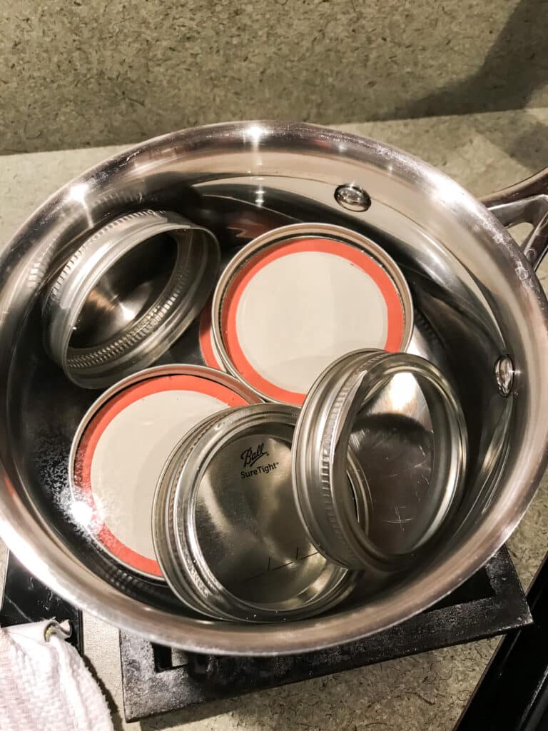 Lids and rings in a pot of boiling water in order to sterilize them.