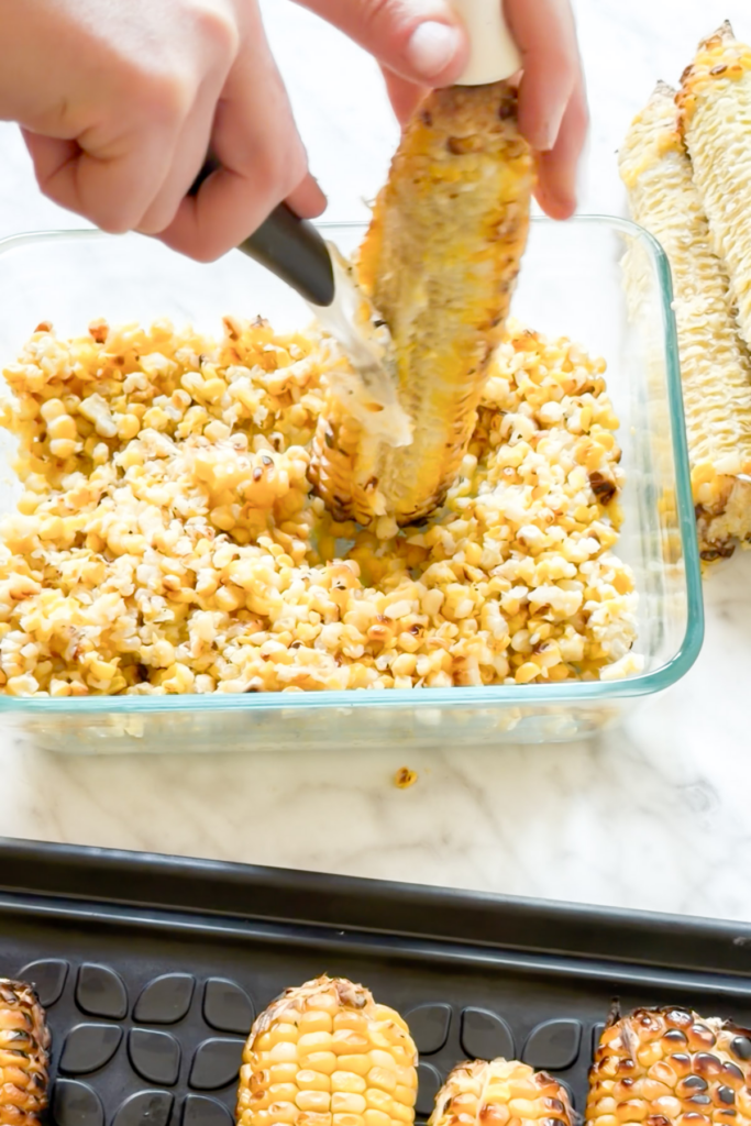 Cutting the kernels off the cob.